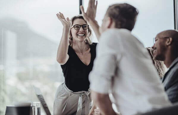 Profesionales celebran con entusiasmo un logro durante una reunión en un entorno de oficina moderno